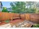 Fenced backyard with wooden bench, stone pathway, and wood-chip ground cover provides relaxation and charm at 2622 Terrace Pkwy, Morrow, GA 30260