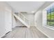 Bright living room featuring hardwood floors, modern staircase, and natural light from the large window at 2622 Terrace Pkwy, Morrow, GA 30260