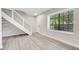 Bright living room featuring hardwood floors, modern staircase, and natural light from the large window at 2622 Terrace Pkwy, Morrow, GA 30260