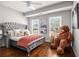 Bright bedroom with plush gray bed, hardwood floors, and filled with natural light from the windows at 3308 Pate Rd, Snellville, GA 30078