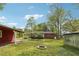 Large backyard with a fire pit, mature trees, and a brick home in the background at 4290 Chestnut Grove Ln, Austell, GA 30106