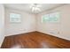 Bright bedroom with hardwood floors, two windows, and neutral walls at 4290 Chestnut Grove Ln, Austell, GA 30106