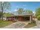 Charming brick home with a covered parking area and a beautifully landscaped front yard with colorful bushes at 4290 Chestnut Grove Ln, Austell, GA 30106