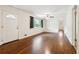 Spacious living room featuring hardwood floors, neutral paint, ceiling fan, natural light from a window, and a front door at 4290 Chestnut Grove Ln, Austell, GA 30106