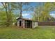 Rustic shed in a backyard surrounded by mature trees and greenery at 4290 Chestnut Grove Ln, Austell, GA 30106