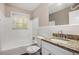 The renovated bathroom features a tub, granite vanity, and updated fixtures at 5052 W Mountain St, Stone Mountain, GA 30083