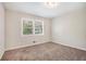 This cozy bedroom features neutral walls, carpet, a window, and overhead lighting at 5052 W Mountain St, Stone Mountain, GA 30083