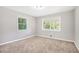 An inviting bedroom features neutral walls, carpet, two windows, and overhead lighting at 5052 W Mountain St, Stone Mountain, GA 30083