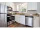 Updated kitchen with stainless steel appliances, granite countertops, and white cabinets at 5052 W Mountain St, Stone Mountain, GA 30083