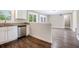 Open kitchen with granite countertops, stainless steel dishwasher, and wood floors at 5052 W Mountain St, Stone Mountain, GA 30083