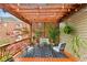 Relaxing back porch area featuring an outdoor seating arrangement, a pergola with string lights, and stylish decor at 963 Manor Parc Dr, Decatur, GA 30033