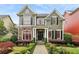 Charming two-story home with stone accents, red framed windows, lush landscaping and inviting curb appeal at 963 Manor Parc Dr, Decatur, GA 30033