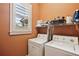 Bright laundry room with window, white washer, dryer and ample storage space at 963 Manor Parc Dr, Decatur, GA 30033
