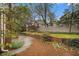 Landscaped backyard featuring a brick retaining wall and mature trees for privacy at 1122 Manning Farms Ct, Atlanta, GA 30338