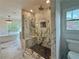 Elegant bathroom featuring marble shower, soaking tub, chandelier, and abundant natural light at 1122 Manning Farms Ct, Atlanta, GA 30338