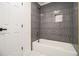 Modern bathroom featuring a tub with gray vertical tile, bronze fixtures, and a storage niche at 1122 Manning Farms Ct, Atlanta, GA 30338