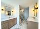 Modern bathroom featuring double vanity, gold fixtures, marble floors, and a large glass shower with marble surround at 1122 Manning Farms Ct, Atlanta, GA 30338