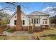 Exterior rear of the home showing a brick chimney, sunroom, and access to a backyard patio at 1122 Manning Farms Ct, Atlanta, GA 30338