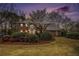 Beautiful two-story brick home with a lush, landscaped front yard at twilight at 1122 Manning Farms Ct, Atlanta, GA 30338