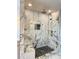 Close up of glass-enclosed shower featuring marble surround and black herringbone tile floor at 1122 Manning Farms Ct, Atlanta, GA 30338