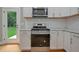 Modern kitchen features stainless steel appliances and sleek white cabinetry and a door to the exterior at 1857 Derrill Dr, Decatur, GA 30032