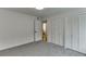 A bright bedroom featuring neutral carpet, ample closet space, and an open doorway at 115 Woodmere Nw Sq # 115, Atlanta, GA 30327