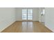 Well-lit dining area with hardwood floors and French doors leading to the outdoors, adjacent to the kitchen at 115 Woodmere Nw Sq # 115, Atlanta, GA 30327