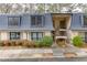 Charming townhouse featuring a gray roof, cream-colored brick, and well-maintained landscaping at 115 Woodmere Nw Sq # 115, Atlanta, GA 30327