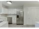 Bright kitchen with stainless steel refrigerator, white cabinets and countertops, and a closet at 115 Woodmere Nw Sq # 115, Atlanta, GA 30327