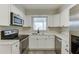 White kitchen featuring stainless steel appliances and sleek countertops at 115 Woodmere Nw Sq # 115, Atlanta, GA 30327