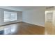 Sunlit living room with gleaming hardwood floors and a large window overlooking the outdoors at 115 Woodmere Nw Sq # 115, Atlanta, GA 30327