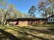 Expansive backyard featuring a brick home with outdoor seating and lush greenery at 4063 Windsor Castle Way, Decatur, GA 30034