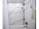 Shower featuring bronze hardware and elegant marble-look tiling at 5210 Chemin De Vie, Atlanta, GA 30342
