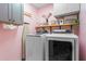 Well-organized laundry room with modern washer and dryer, shelving, and charming decor at 5729 Brookstone Nw Walk, Acworth, GA 30101