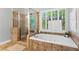 Bright main bathroom features tiled flooring, a standalone shower, and a soaking tub by the window at 5729 Brookstone Nw Walk, Acworth, GA 30101