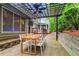 Outdoor patio with pergola, ceiling fan, dining table, and wooded backyard, perfect for entertaining at 5729 Brookstone Nw Walk, Acworth, GA 30101