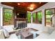Inviting sunroom featuring a stone fireplace, wood ceiling, and serene outdoor views at 5729 Brookstone Nw Walk, Acworth, GA 30101