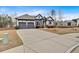 View of a single-story home with a long driveway leading to a two-car garage and landscaped front yard at 114 Montgomery Ln, Villa Rica, GA 30180
