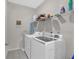 Functional laundry room with washer, dryer, wire shelves and gray tile flooring at 114 Montgomery Ln, Villa Rica, GA 30180