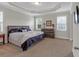 The main bedroom showcases a tray ceiling, large bed and a dresser with a framed piece of art on it at 114 Montgomery Ln, Villa Rica, GA 30180