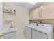 Laundry room featuring a washer, dryer, sink, and overhead storage at 362 Battle Woods Nw Trl, Marietta, GA 30064