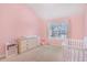 Bright bedroom featuring a vaulted ceiling, large window, and a charming baby crib at 3642 Sunbridge Dr, Snellville, GA 30039