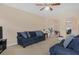 Spacious living room with blue sofas, ceiling fan, and lots of natural light, creating an inviting atmosphere at 3642 Sunbridge Dr, Snellville, GA 30039