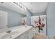 Bathroom featuring double sinks, large mirror, decorative shower curtain, and light blue walls at 111 Riverstone Commons Cir, Canton, GA 30114