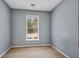 This is a small bedroom with a window letting in natural light, grey walls, and neutral carpet at 111 Riverstone Commons Cir, Canton, GA 30114