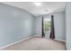 Bedroom showcasing neutral carpet, light blue walls, a window with curtains, and ample natural light at 111 Riverstone Commons Cir, Canton, GA 30114