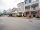 Exterior view of townhome, featuring brick accents, multiple windows, and a well-maintained front lawn at 111 Riverstone Commons Cir, Canton, GA 30114