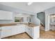 Bright kitchen with white cabinets, breakfast bar, and view to the stairs and adjacent bathroom at 111 Riverstone Commons Cir, Canton, GA 30114