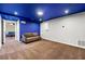 Finished basement offers a calming blue accent wall, neutral carpet, and bright recessed lighting at 1460 Edgemont Pt, Lawrenceville, GA 30044