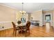 Elegant dining room with hardwood floors, a glass-top table, and views into the living spaces at 1460 Edgemont Pt, Lawrenceville, GA 30044